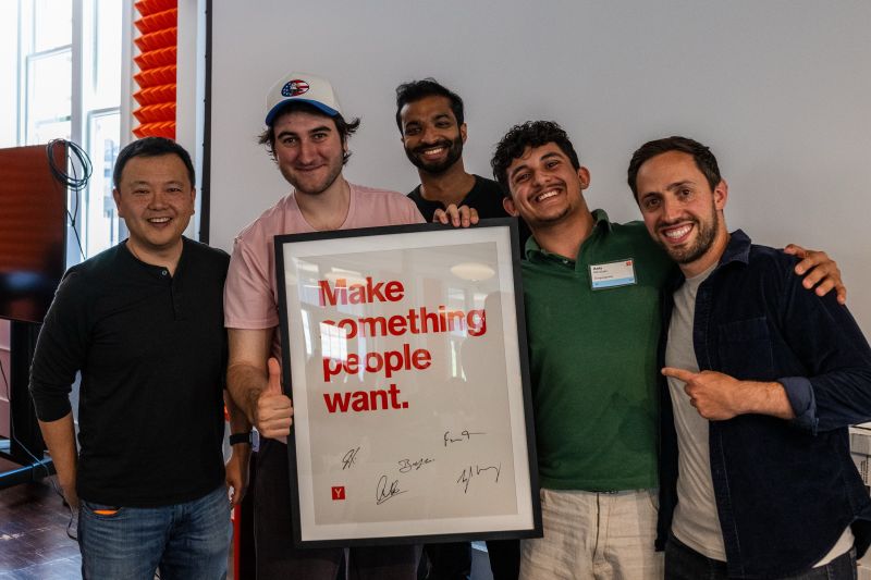 GutGut Goose founders and supporters holding a signed Make something people want poster at Y Combinator